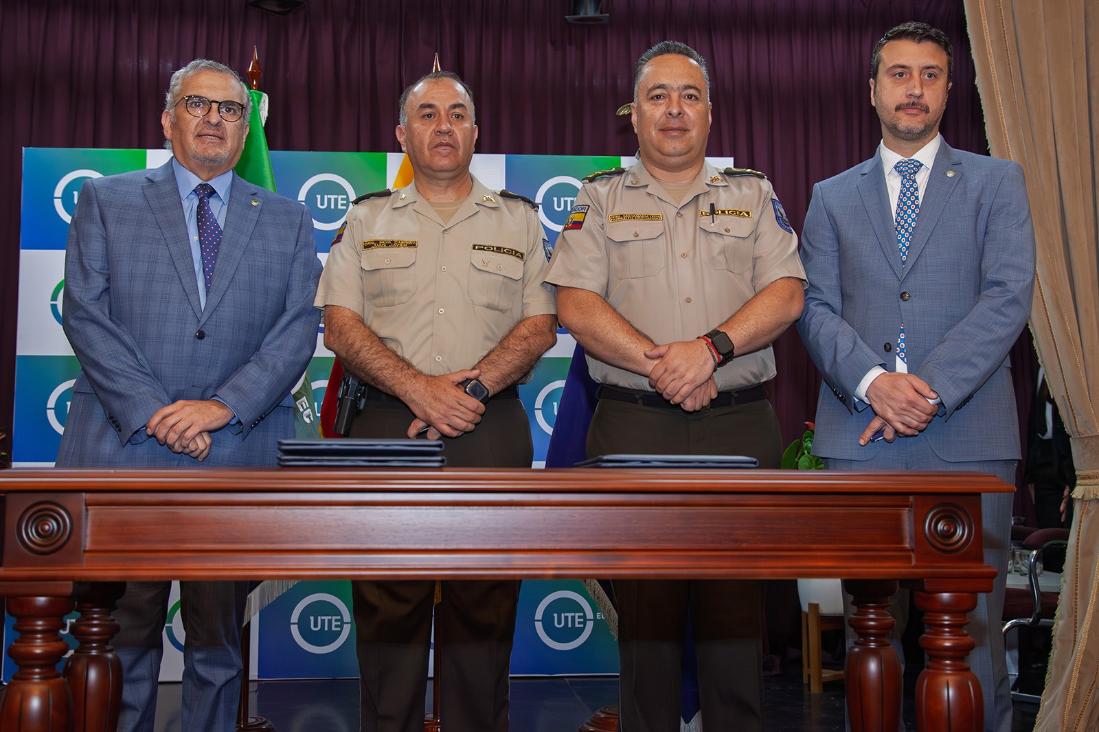 Representantes institucionales de la UTE y el ISSPOL en acto oficial de cooperación académica, con presencia de autoridades y público asistente.